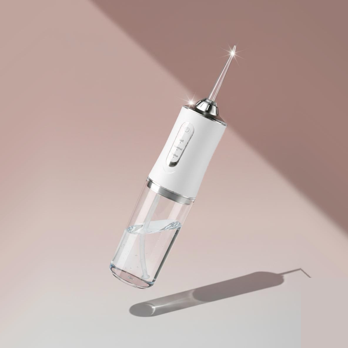 White Flossify cordless water flosser floating against a soft pink background
